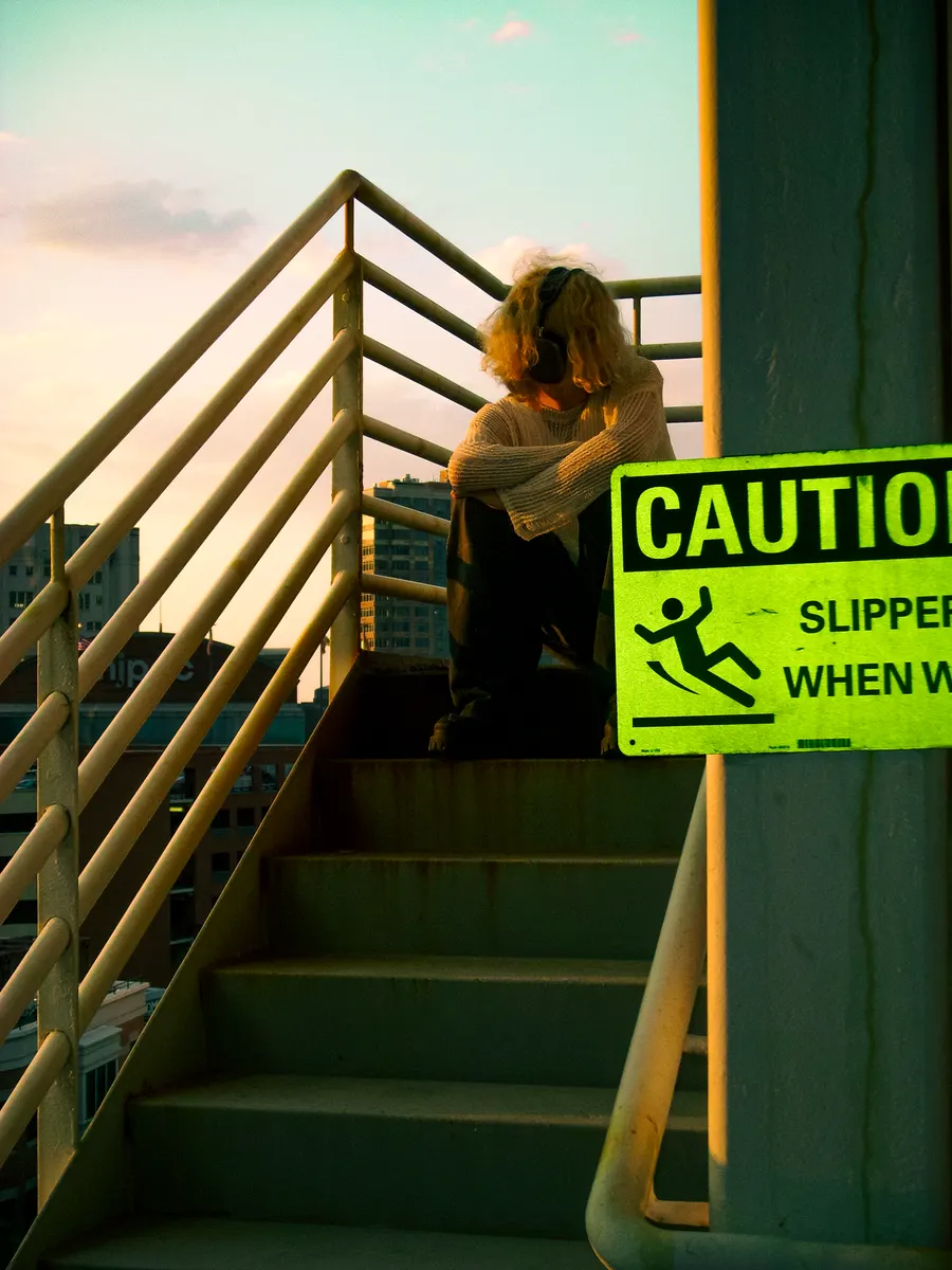 Jordan Andrew on a stairwell beside a yellow caution sign