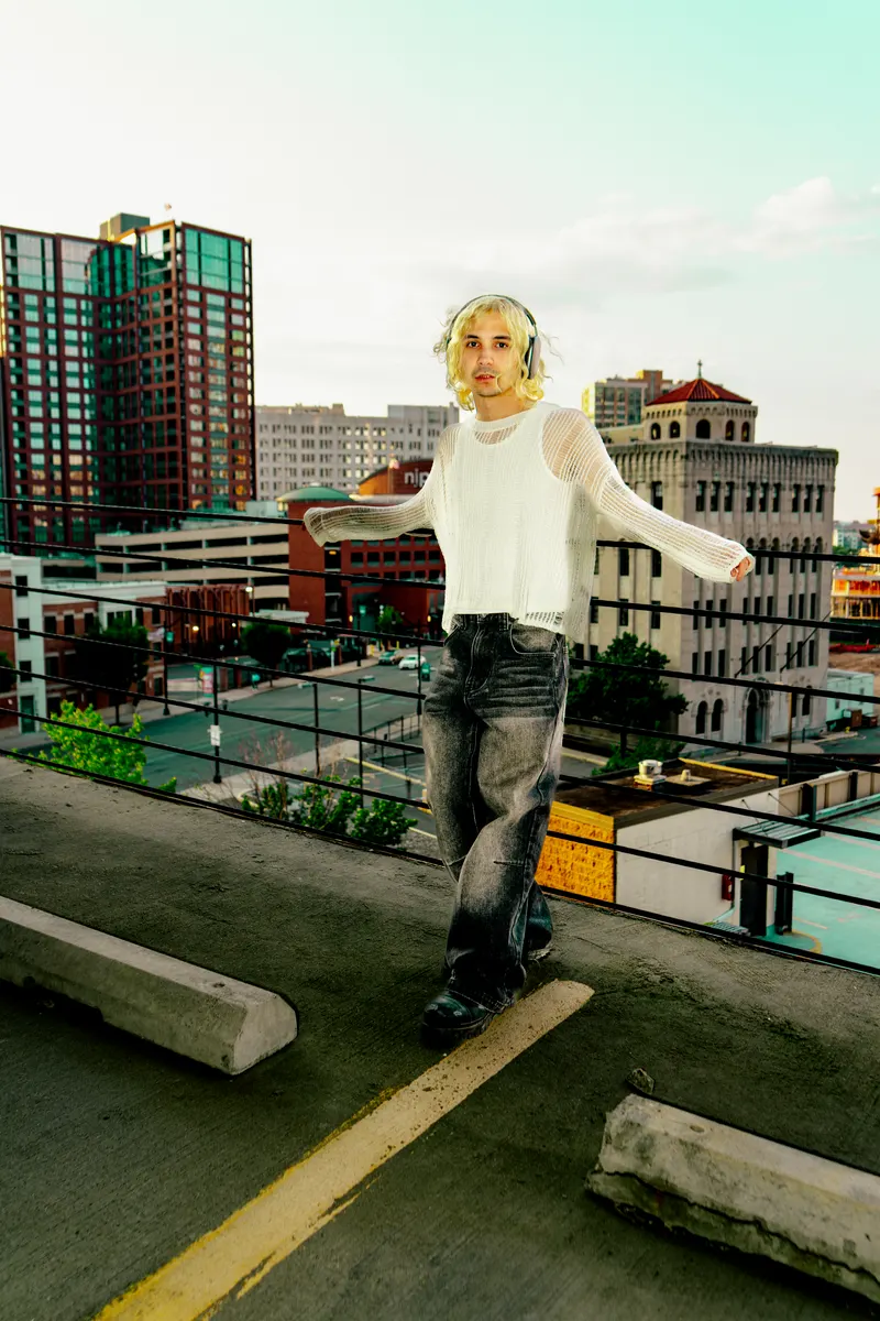 Jordan Andrew on a rooftop above the city skyline