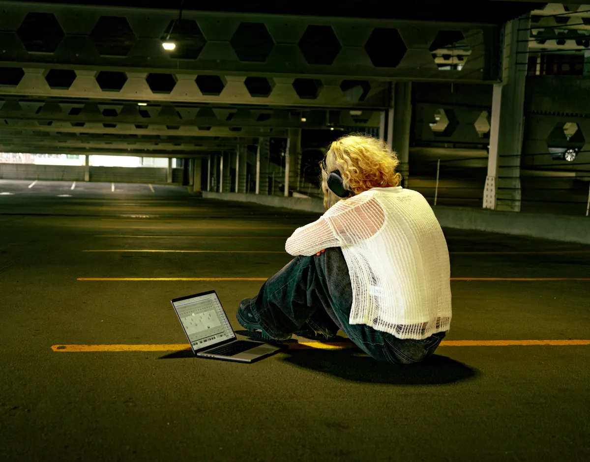 Jordan Andrew sitting in a parking garage with a laptop