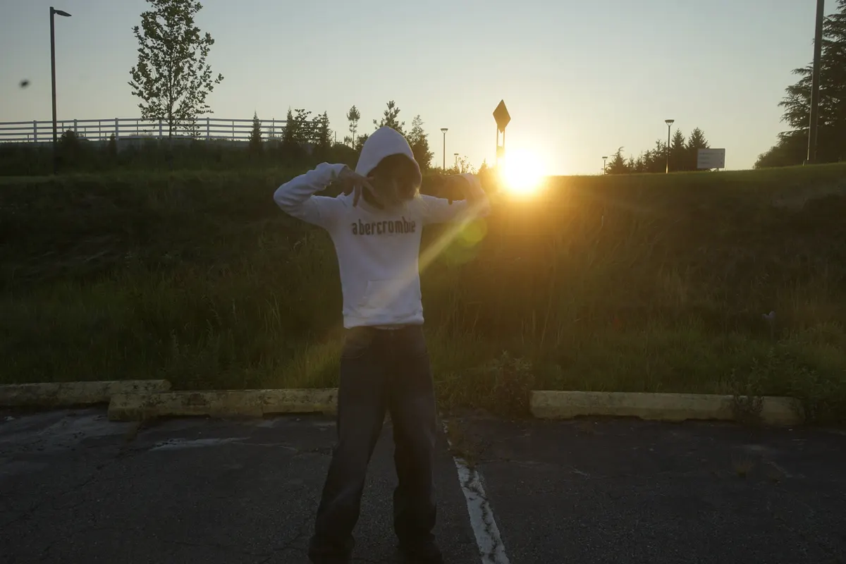 Jordan Andrew in a white hoodie at sunset
